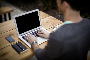 man achter laptop