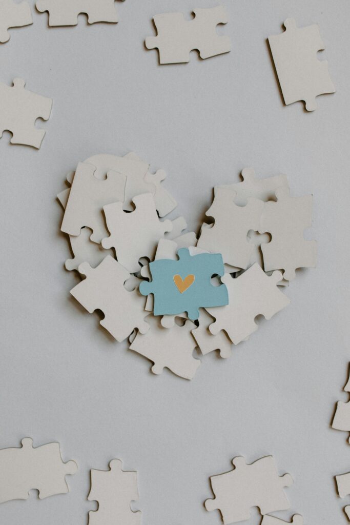 A heart-shaped puzzle arrangement with a central blue piece featuring a gold heart symbol.